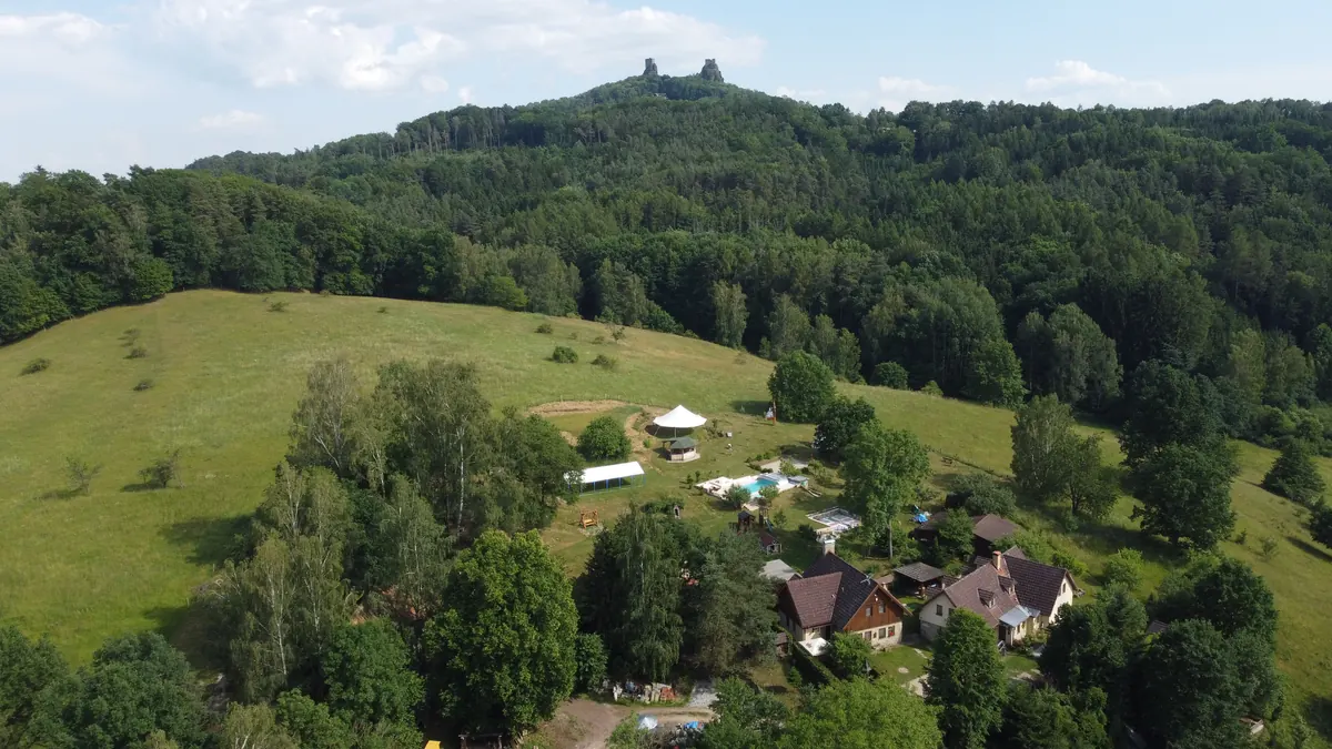 Letecký pohled na Miniresort AMULET na úpatí kopce se zříceninou hradu Trosky