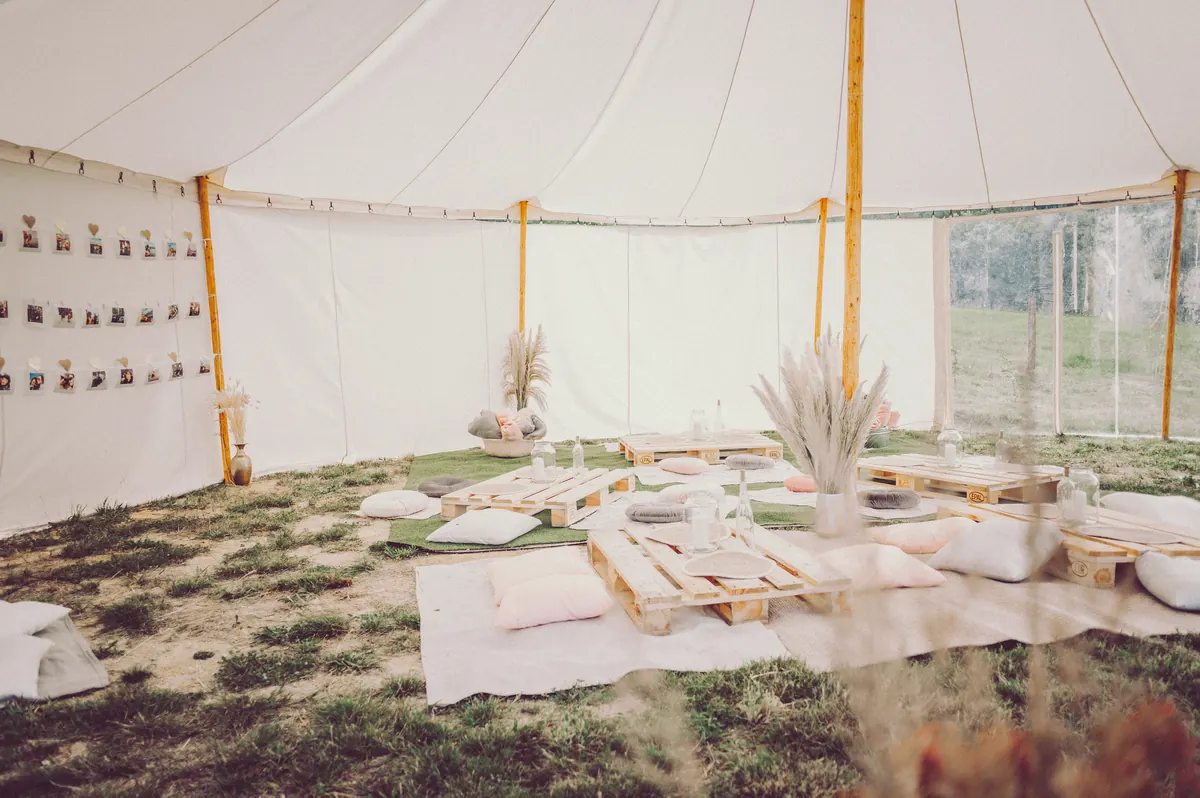 Boho odpočinková zóna ve velkém stanu s polštáři a pampou
